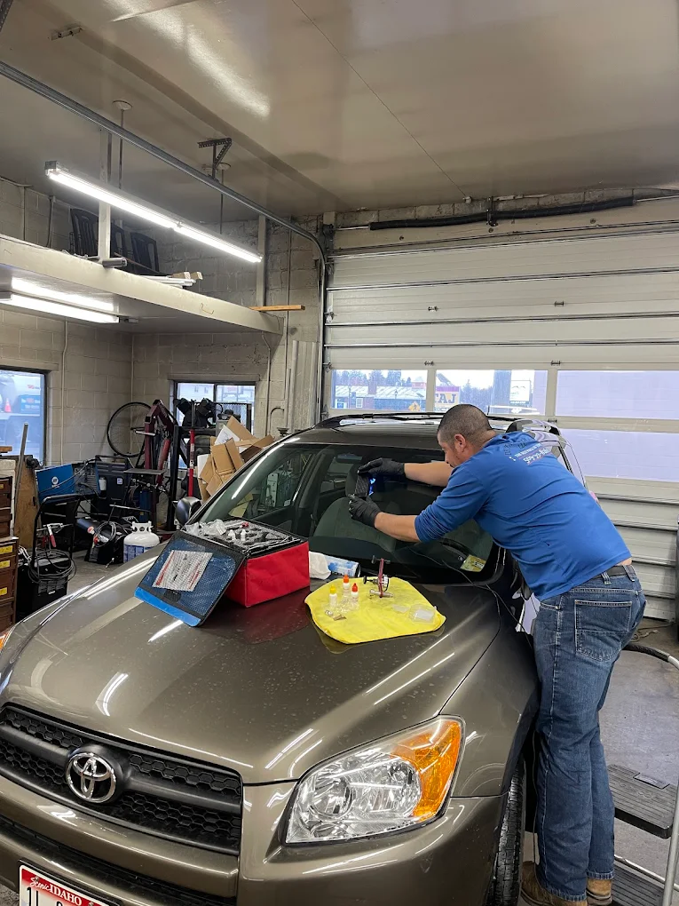 Technician performing chip repair on Toyota RAV4 windshield with resin tools